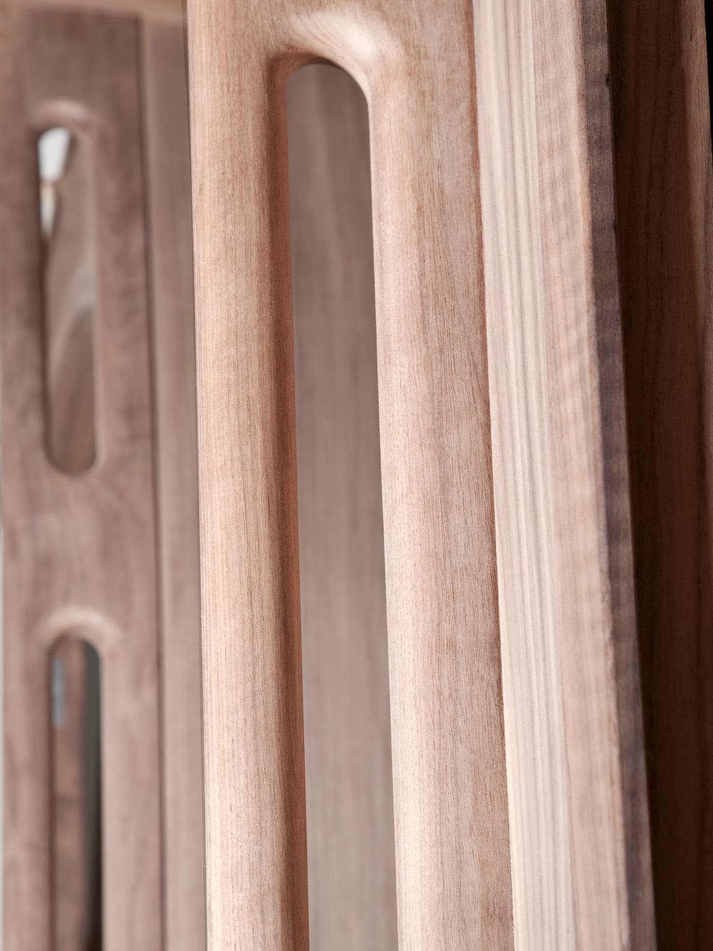 Close-up van een uitgefreesde handgreep in een houten paneel, met de nerf scherp in beeld