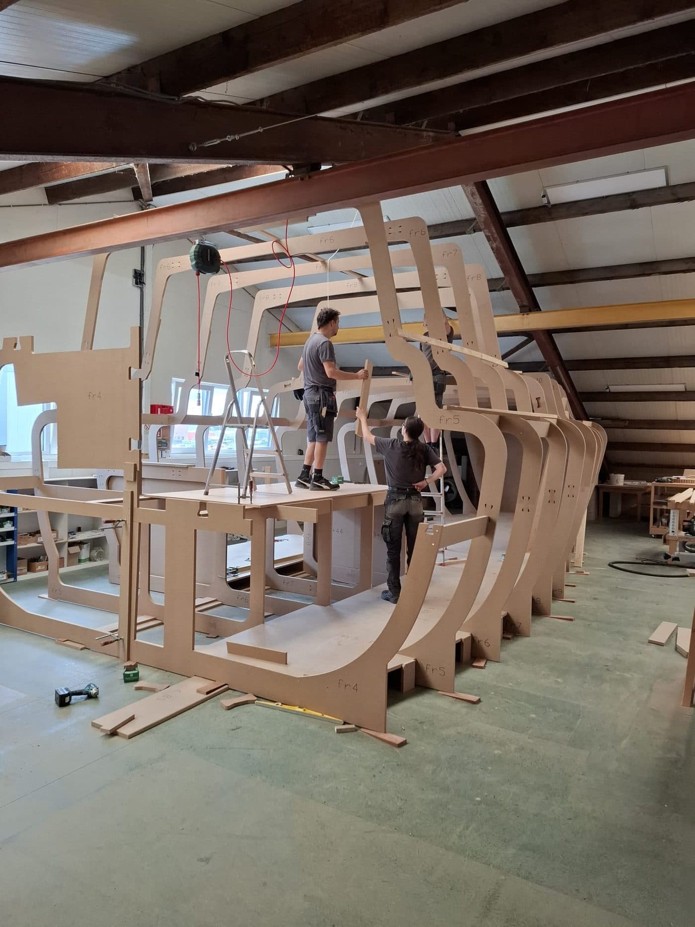 Twee medewerkers bouwen een mock-up van een nieuwbouwschip in de werkplaats